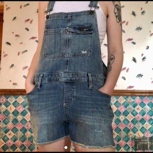 soft blue denim overall shorts with frayed bottoms